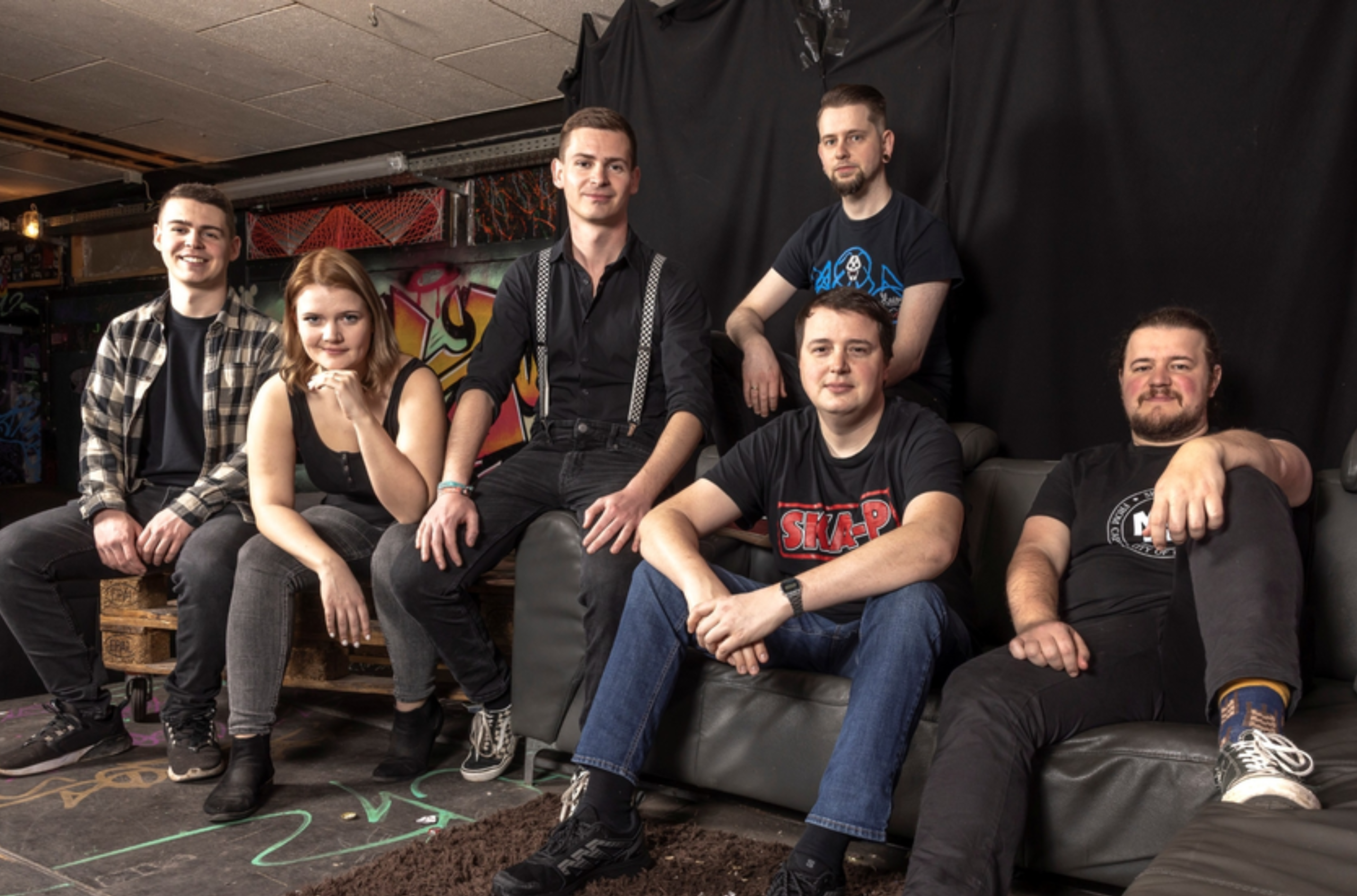 Bandportrait Skabooom vor dunklem Hintergrund.