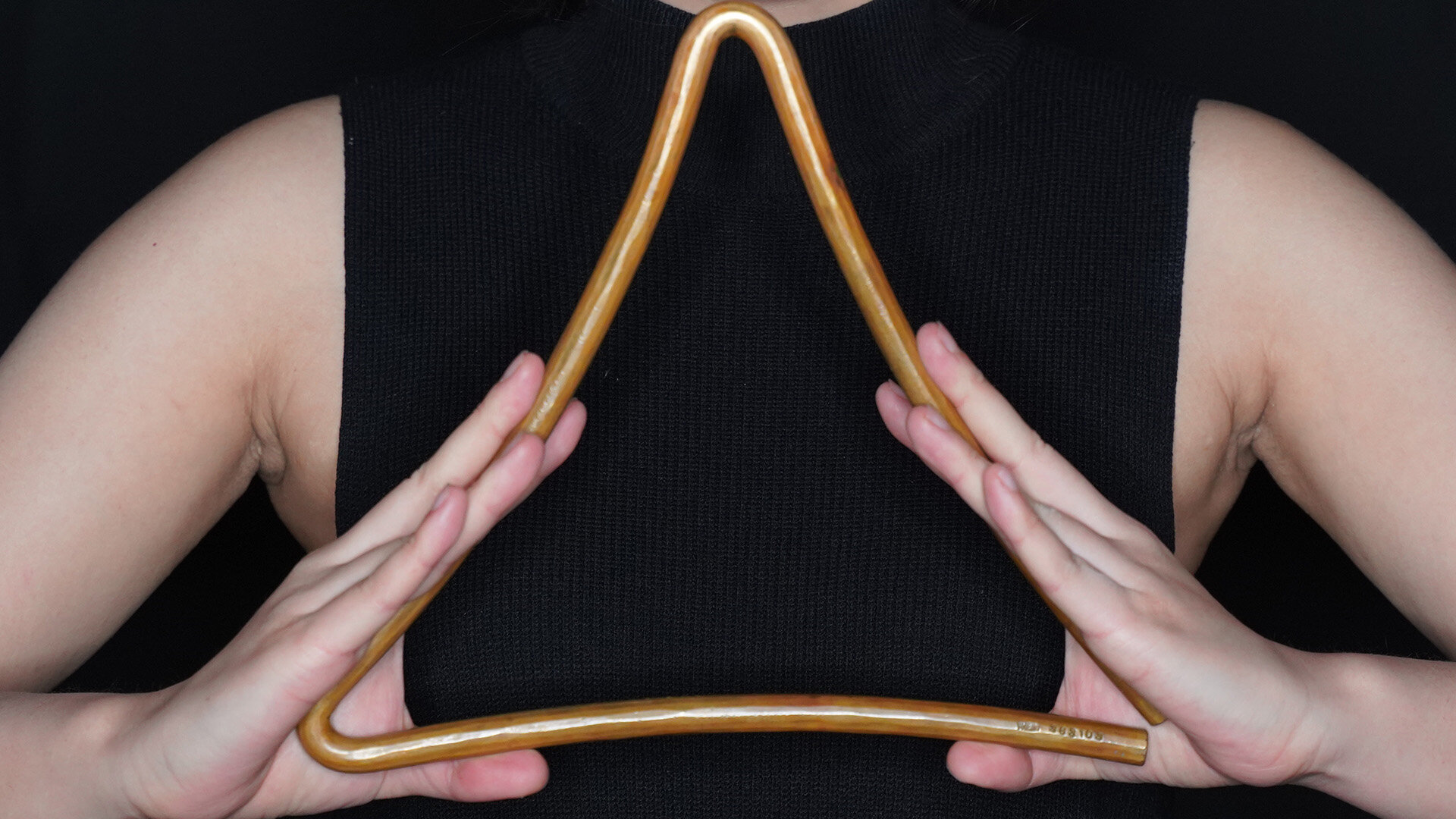 Eine Frau hält eine Triangel vor sich