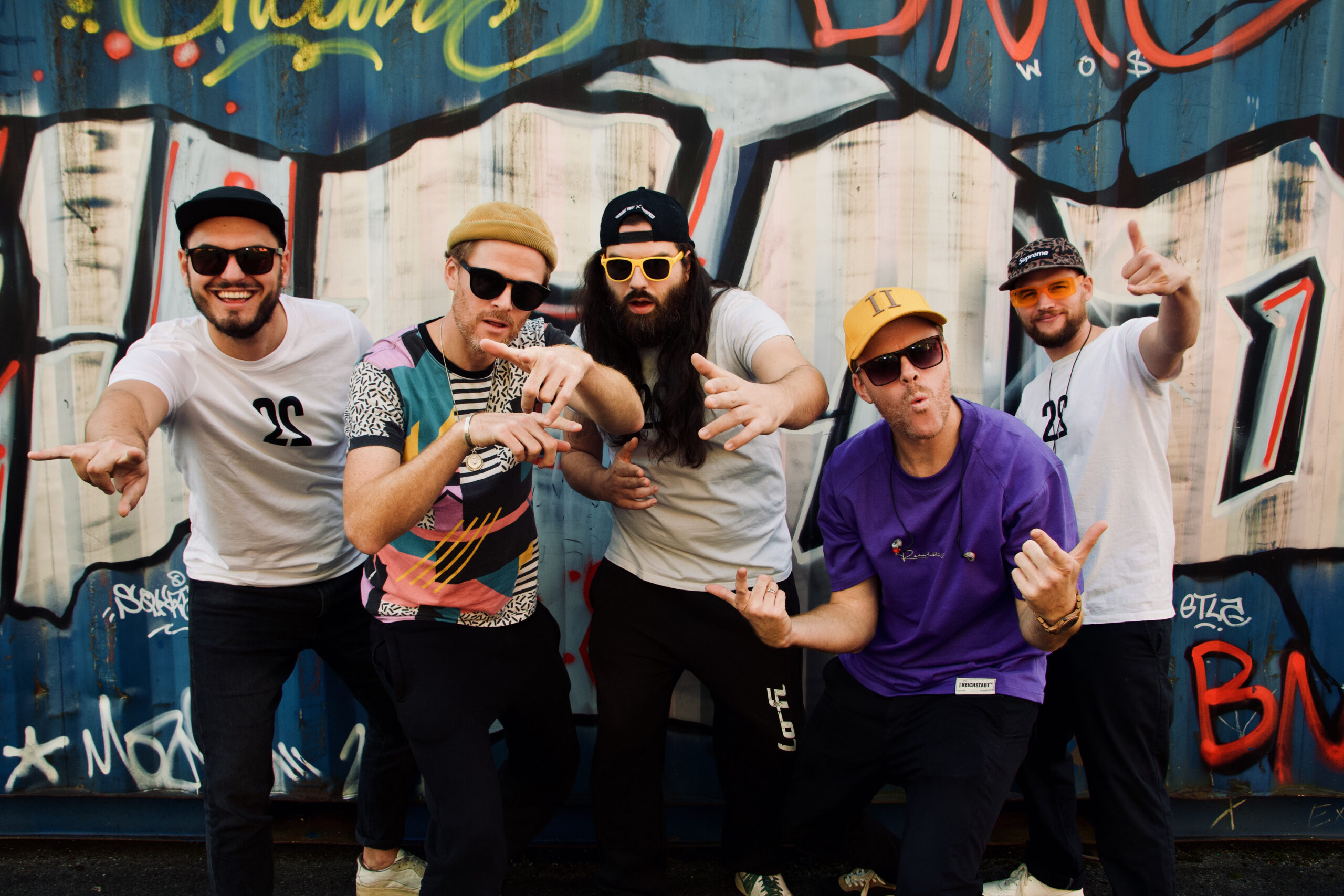 Die Hip-Hop Gruppe Zweierpasch vor einer Graffiti-Wand.